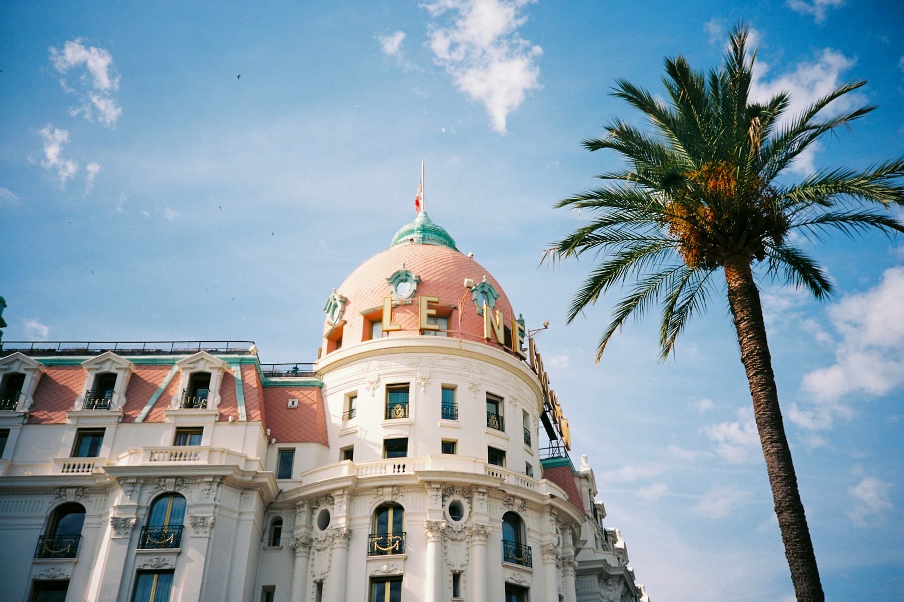 La coupole du Negresco et un palmier sous le ciel bleu